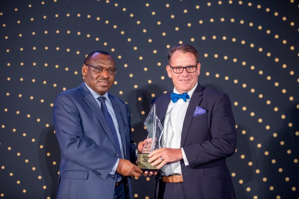 Minister of Infrastructure and Guest of Honor, Amb. Claver Gatete (L) hands over the 2018 RDB Business Excellence Awards Investor of the Year award to I&M Bank Rwanda’s MD, Robin Bairstow (R)