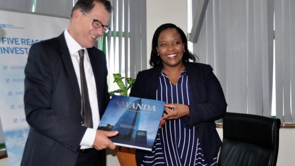 RDB CEO, Clare Akamanzi (R) hands over a book that explains Rwanda’s transformational growth story to the German Minister, Gerd Muller (L) today